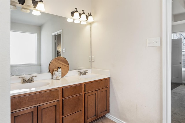 full bathroom featuring double vanity, baseboards, and a sink