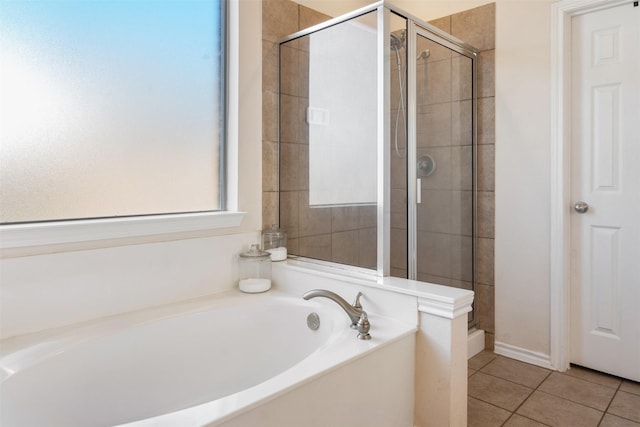 bathroom featuring tile patterned flooring, a shower stall, and a bath