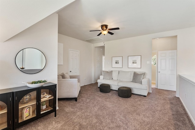 carpeted living area featuring a ceiling fan, visible vents, and baseboards