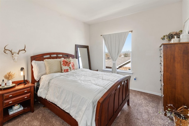 bedroom with dark carpet and baseboards