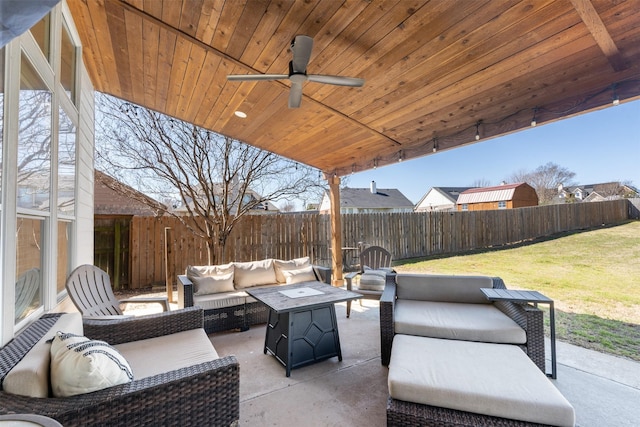 view of patio with ceiling fan, an outdoor living space with a fire pit, and a fenced backyard