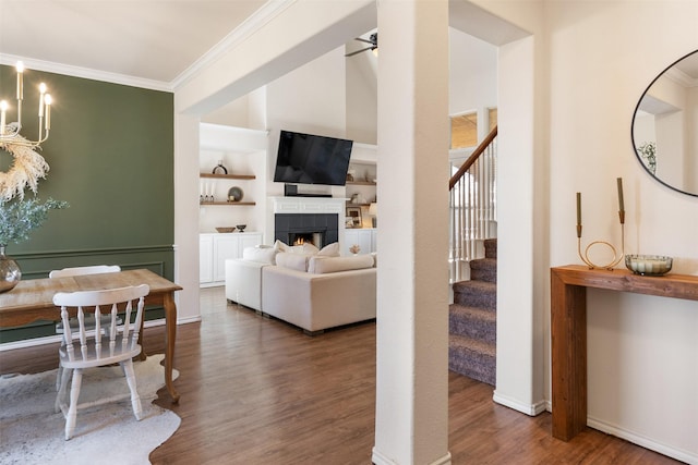 living area featuring crown molding, stairway, and wood finished floors