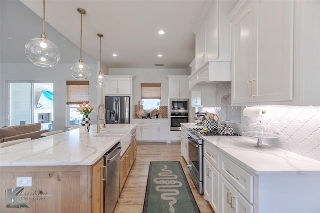 kitchen featuring stainless steel appliances, tasteful backsplash, light wood-type flooring, and a wealth of natural light