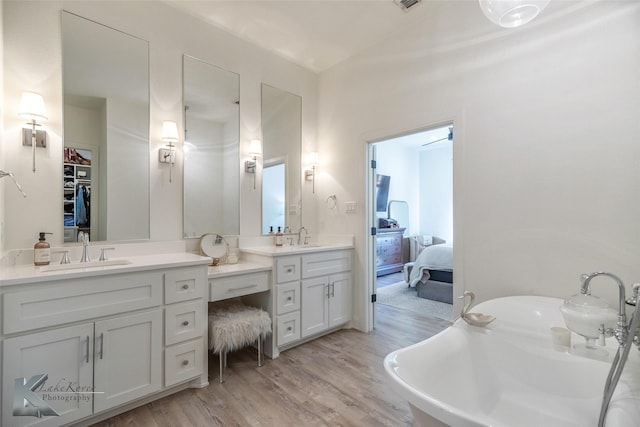 full bathroom with a soaking tub, vanity, ensuite bath, and wood finished floors