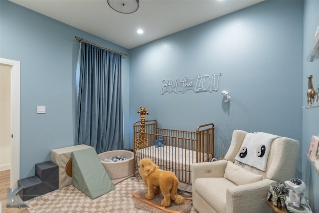 bedroom featuring a nursery area and recessed lighting