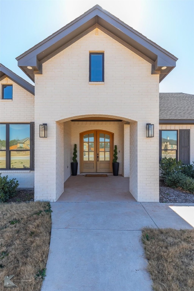 view of exterior entry with french doors and brick siding