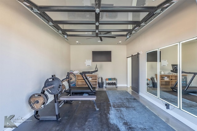 workout area with a garage, a barn door, and baseboards