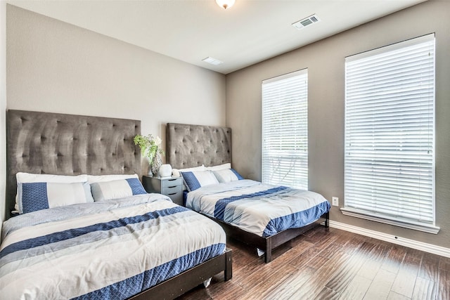 bedroom with wood-type flooring, visible vents, and baseboards