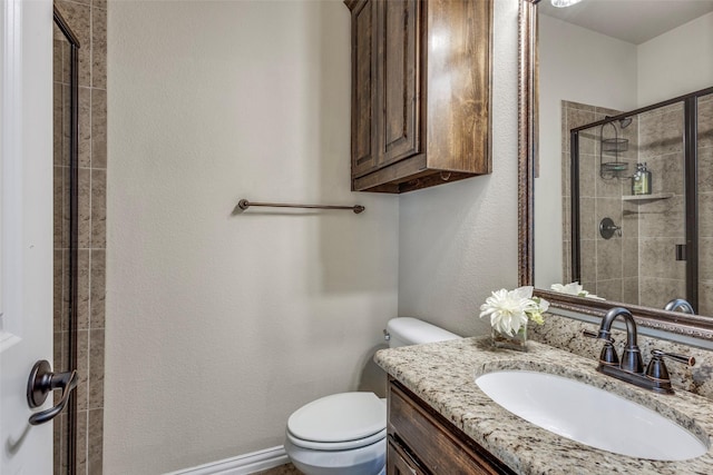 bathroom with a stall shower, vanity, and toilet