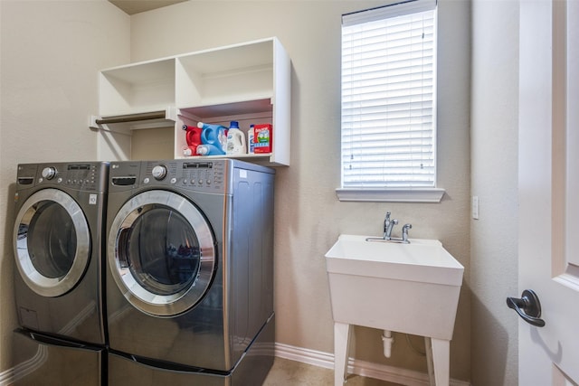 laundry room featuring laundry area, a sink, washer and clothes dryer, and baseboards