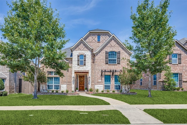 1080 Chestnut Dr, Frisco, TX 75036 - french country style house with a front yard, stone siding, and brick siding