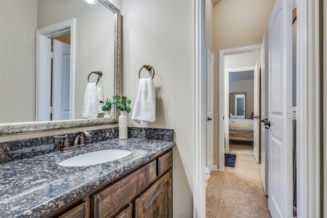 ensuite bathroom featuring tile patterned floors, ensuite bath, and vanity