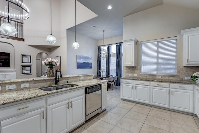 kitchen featuring a sink, white cabinets, light stone countertops, dishwasher, and tasteful backsplash