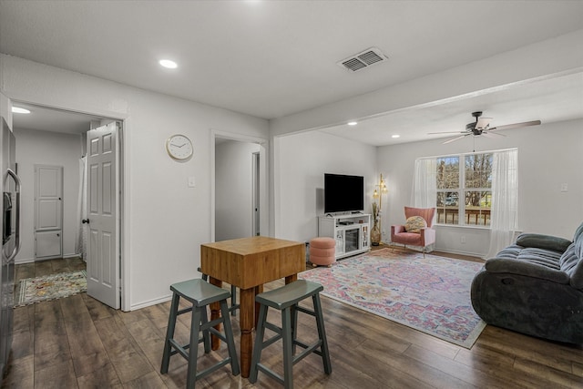 living area with recessed lighting, visible vents, and dark wood finished floors