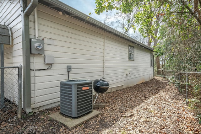 view of property exterior featuring cooling unit and fence