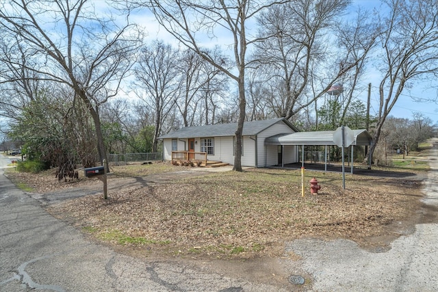 ranch-style house with a carport, driveway, and a deck