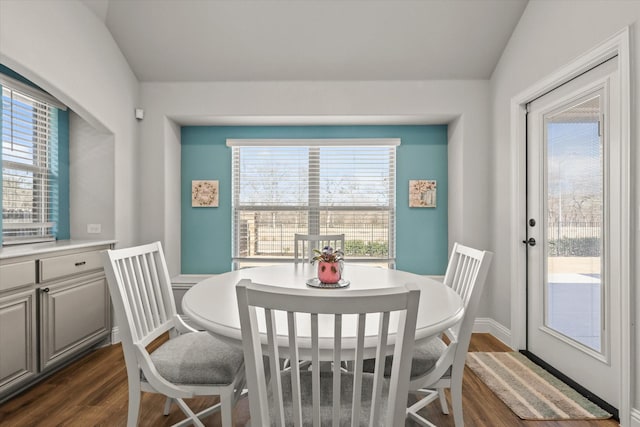 dining area featuring a healthy amount of sunlight, baseboards, dark wood finished floors, and lofted ceiling