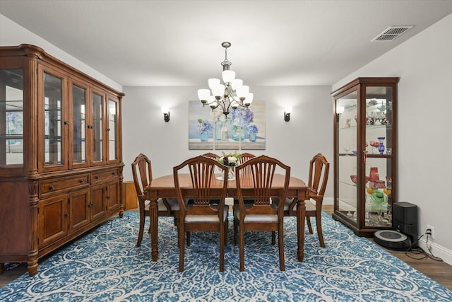 dining room with baseboards, visible vents, a chandelier, and dark wood-type flooring