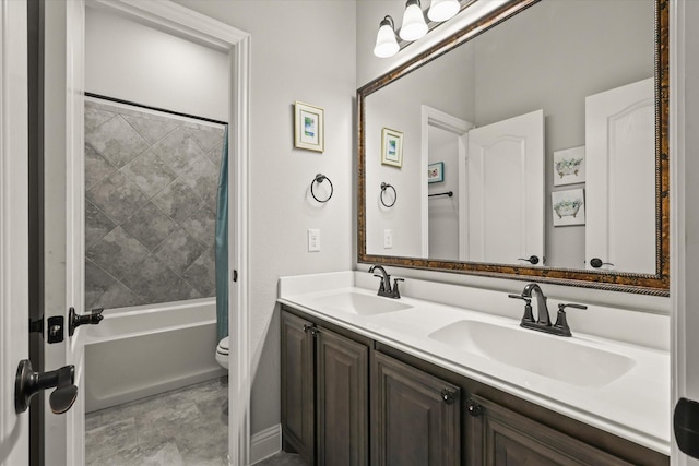 bathroom featuring tub / shower combination, a sink, toilet, and double vanity