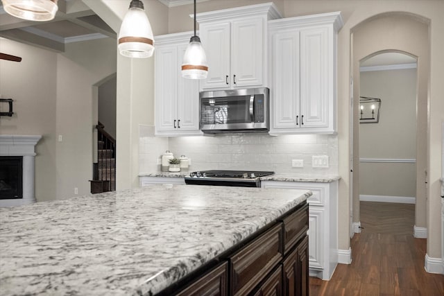 kitchen featuring backsplash, stainless steel appliances, and ornamental molding