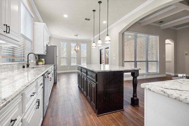 kitchen with visible vents, a sink, arched walkways, white cabinets, and dark wood-style flooring