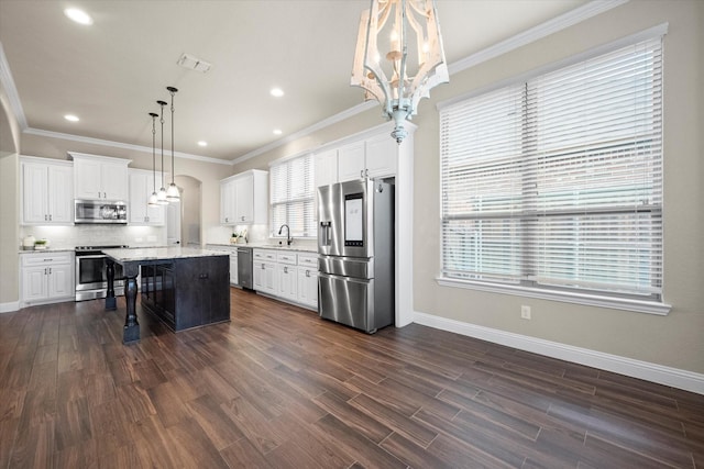 kitchen with a breakfast bar, an inviting chandelier, dark wood-style flooring, and appliances with stainless steel finishes