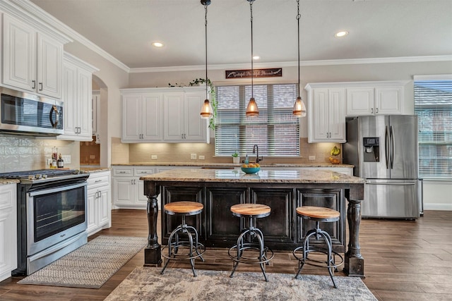 kitchen featuring stainless steel appliances, dark wood-type flooring, a breakfast bar, and white cabinets