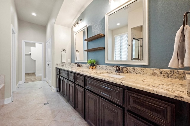 full bath with double vanity, visible vents, a shower with door, and a sink