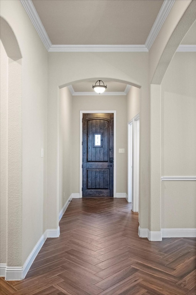 foyer entrance featuring crown molding, baseboards, and arched walkways