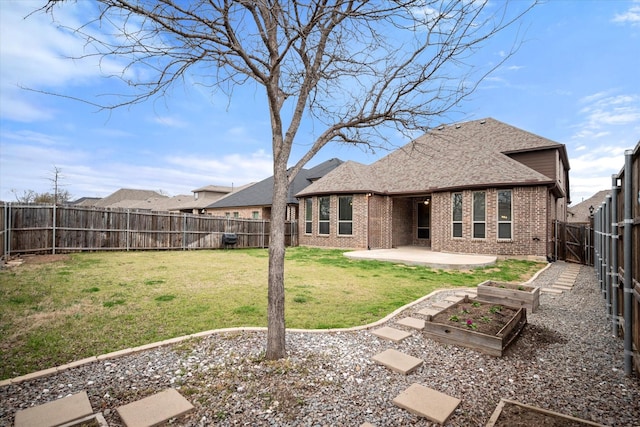 back of house with brick siding, a vegetable garden, a fenced backyard, a yard, and a patio