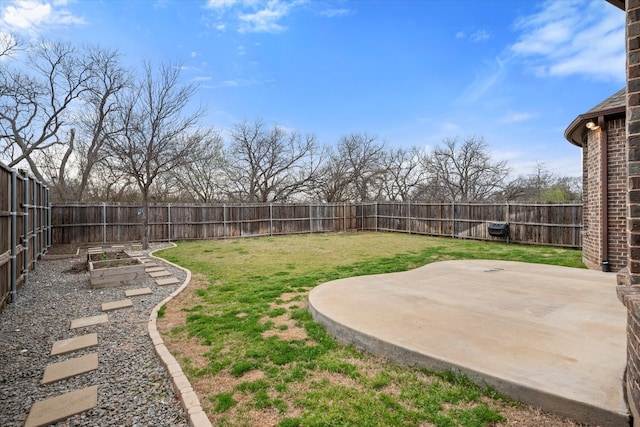 view of yard with a garden, a fenced backyard, and a patio area