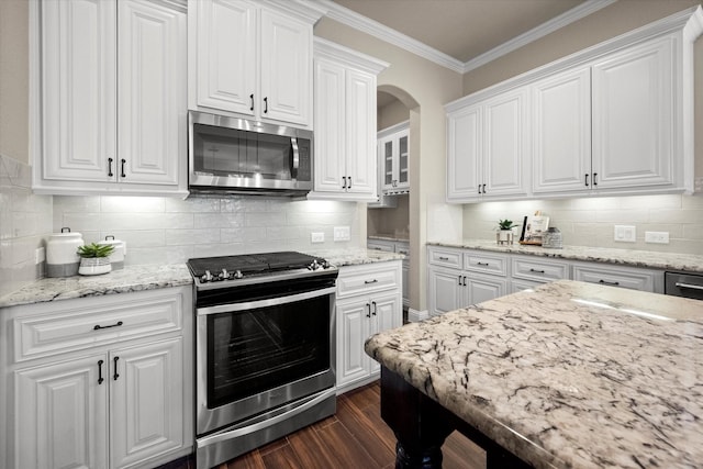 kitchen with white cabinetry, crown molding, dark wood finished floors, and appliances with stainless steel finishes