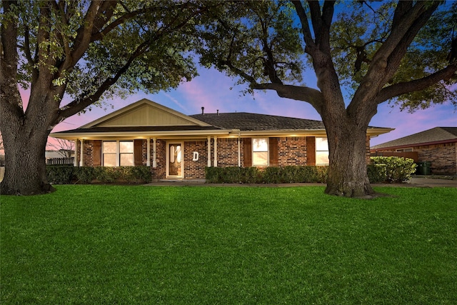 ranch-style home with brick siding and a front yard