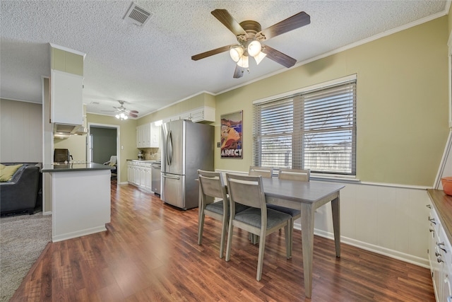 dining room with dark wood-style floors, crown molding, visible vents, and a textured ceiling