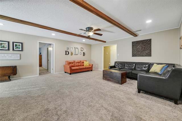 carpeted living area with beam ceiling, visible vents, ceiling fan, a textured ceiling, and baseboards