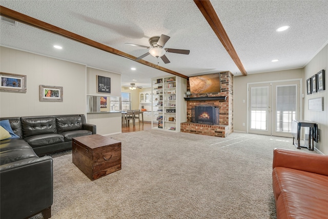 carpeted living room featuring a brick fireplace, plenty of natural light, a textured ceiling, and french doors