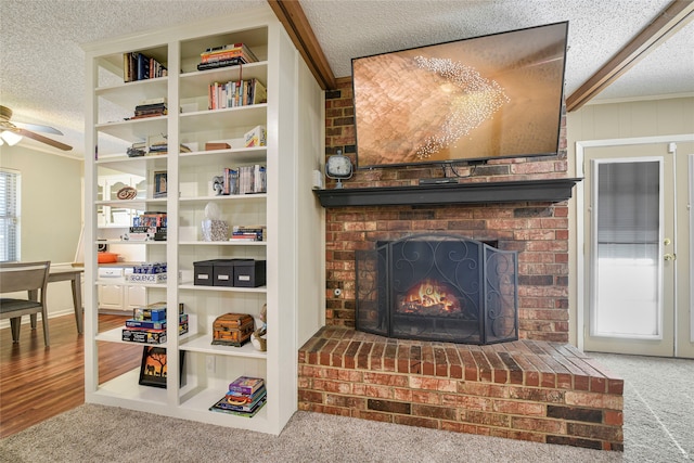 details with carpet, a ceiling fan, a brick fireplace, a textured ceiling, and wood finished floors