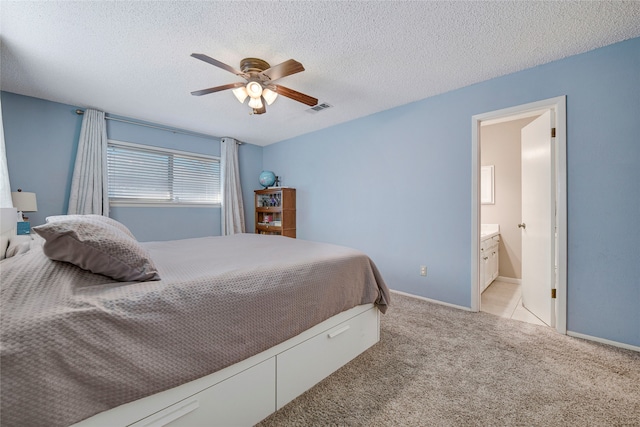 bedroom featuring light carpet, baseboards, visible vents, and a textured ceiling