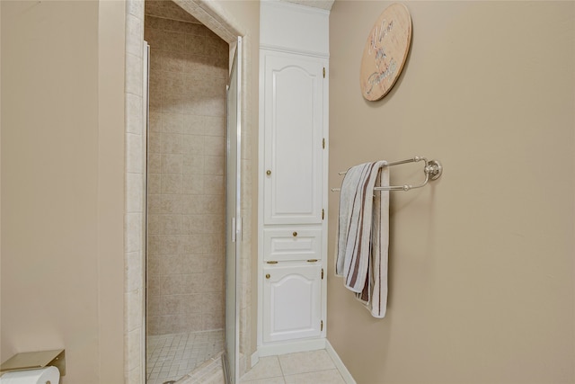 bathroom with a stall shower, baseboards, and tile patterned floors