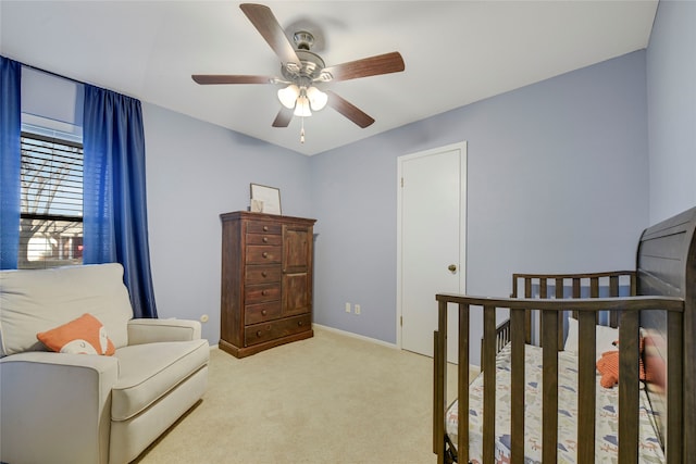 bedroom with ceiling fan, baseboards, and light colored carpet