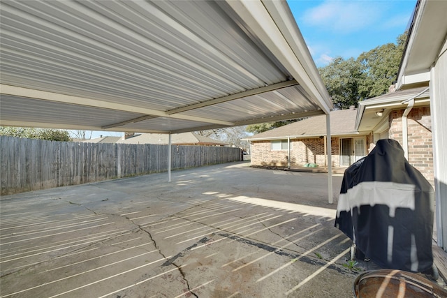 view of patio featuring fence and driveway