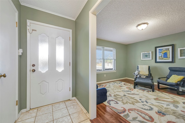 tiled foyer entrance featuring baseboards and a textured ceiling