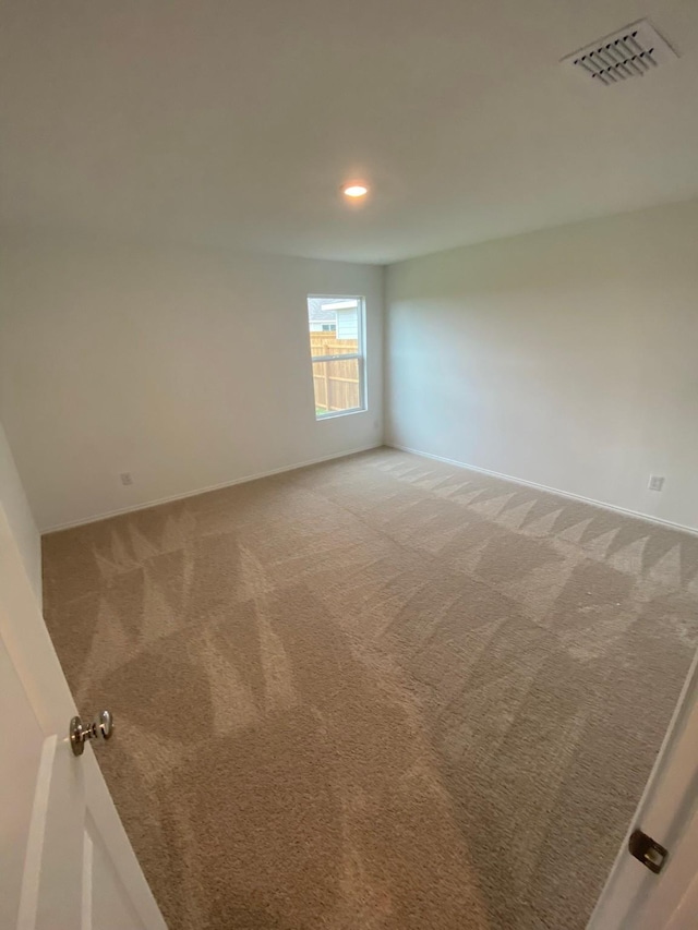 spare room with baseboards, recessed lighting, visible vents, and light colored carpet