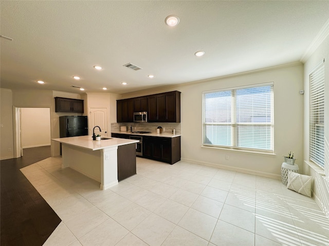 kitchen with crown molding, light countertops, visible vents, appliances with stainless steel finishes, and a sink