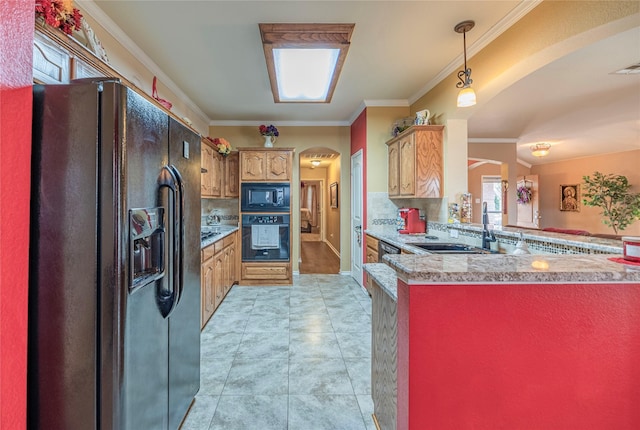 kitchen featuring tasteful backsplash, arched walkways, crown molding, black appliances, and a sink