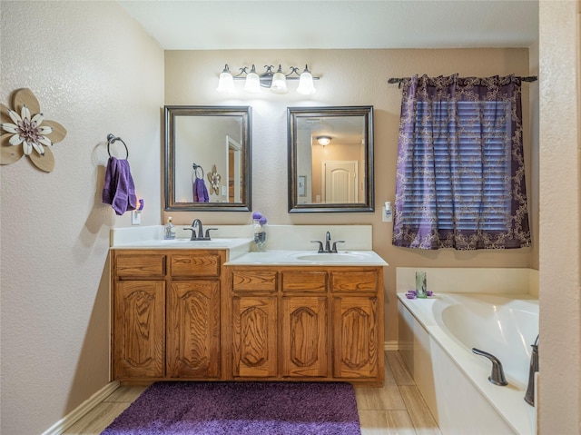 full bath with double vanity, a garden tub, baseboards, and a sink