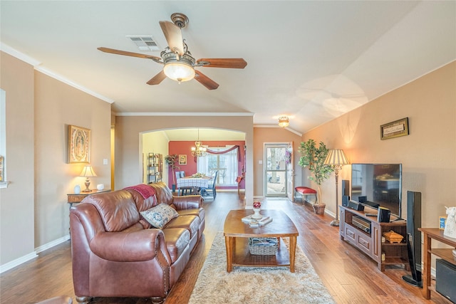 living area with baseboards, wood finished floors, visible vents, and crown molding