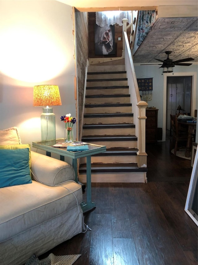 stairs featuring ceiling fan and hardwood / wood-style flooring