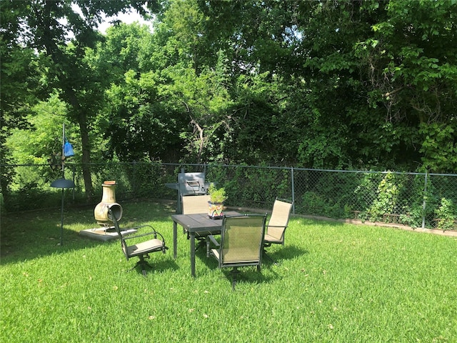 view of yard with fence and outdoor dining area