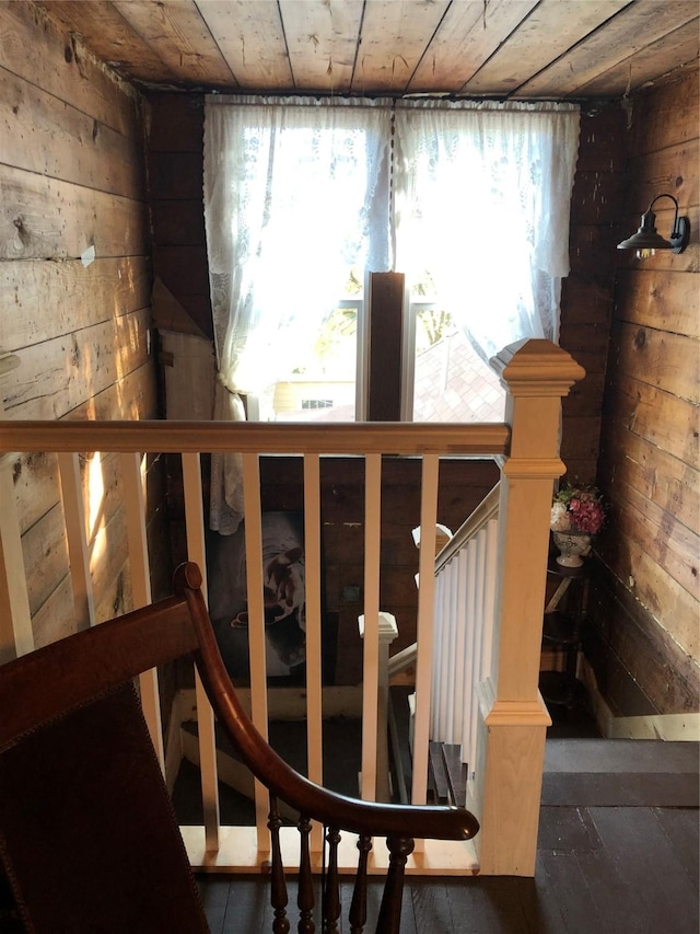 staircase with wood walls and plenty of natural light